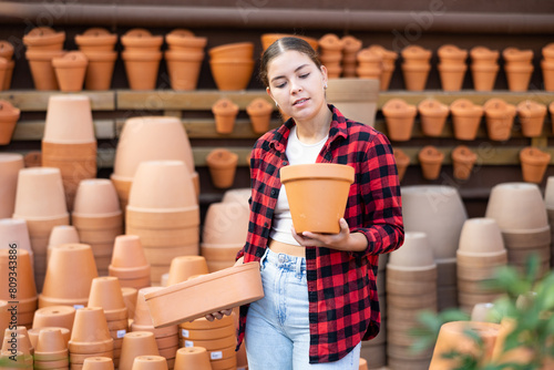 Foto Portrait of a young European woman choosing flower pots for indoor plants at the