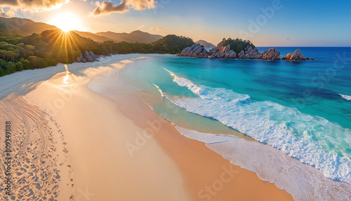 A beautiful sandy beach scene with a sunrise in the background. The water is calm, and there are no waves crashing onto the shore. The sky appears to be clear, allowing the sun to shine brightly.