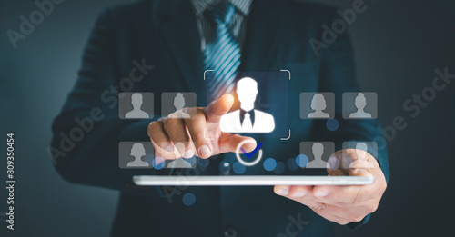 Human resource management concept. Businessman holding virtual human icon on hand choose employees fo teamwork Customer Relation Management focus target group social media. Digital marketing online.