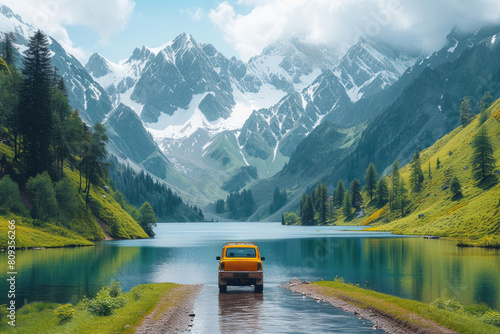 Car on a road near a lake and mountains with snow-capped peaks. photo