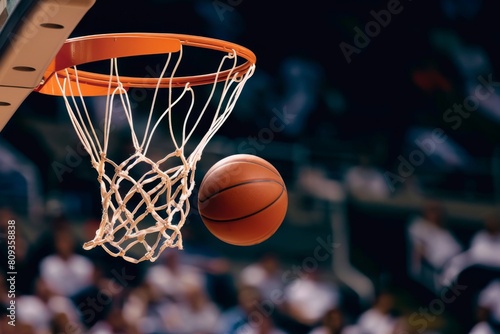 Basketball ball falling through the hoop in a lit gym © InfiniteStudio