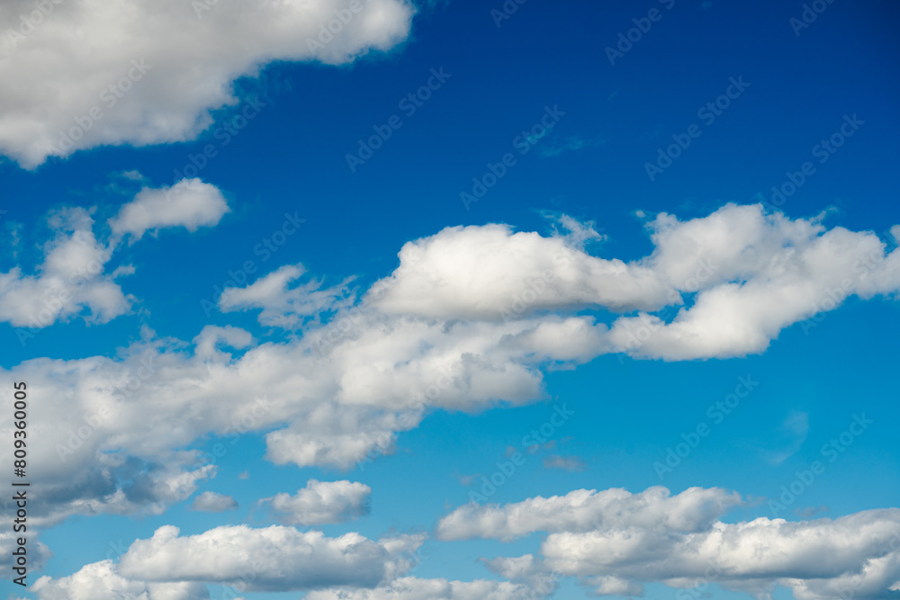 Fototapeta premium Scattered Clouds Across a Bright Blue Sky