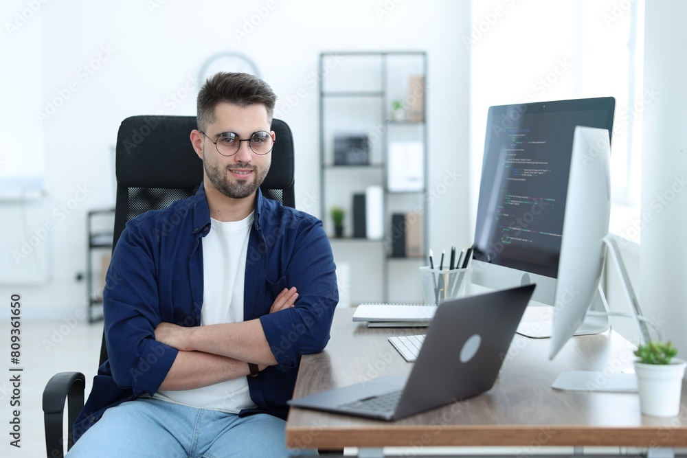 Happy young programmer working with laptop in office Happy young programmer working with laptop in office