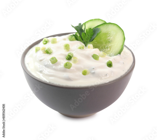 Delicious yogurt with green onion, cucumbers and parsley in bowl isolated on white