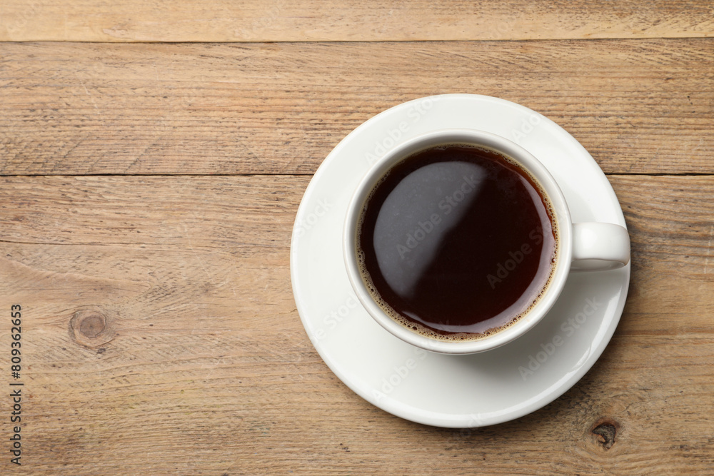 Cup of aromatic coffee on wooden table, top view. Space for text Cup of aromatic coffee on wooden table, top view. Space for text