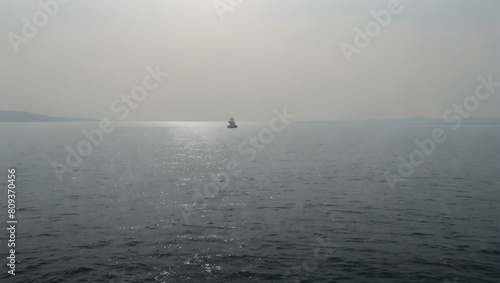 A solitary sea, a lone ship navigates the vast expanse against a backdrop of pure white ai_generated