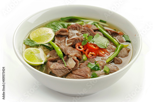 a bowl of beef and vegetables with a lime slice