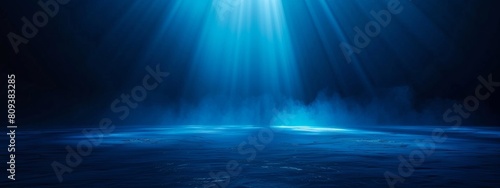 Dark blue background with light rays, glowing and shining on the floor, creating an atmospheric effect. © SH Design