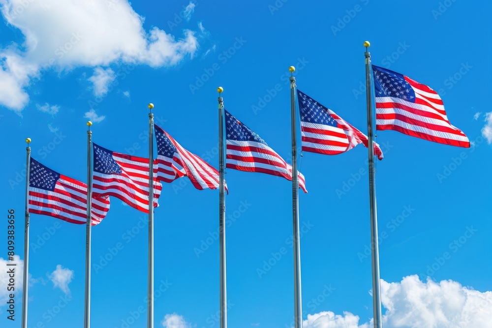 American flags waving in the wind on a background of blue sky.