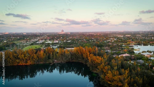 Aerial Pan of Wolf Lake Park in Davie, Florida, with Hard Rock Casino Guitar Hotel in the Background,  showcasing vibrant greenery, & a serene lake photo