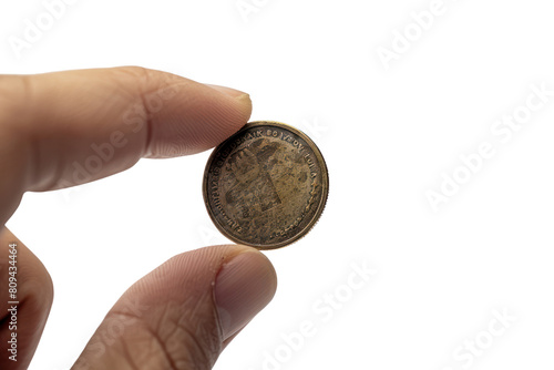 A hand placing a small magnet on a pile of money, causing the bills and coins to jump up and attach themselves to the magnet, realistic photos on a white background
