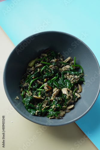 Top view of bowl with cooked spinach on table 