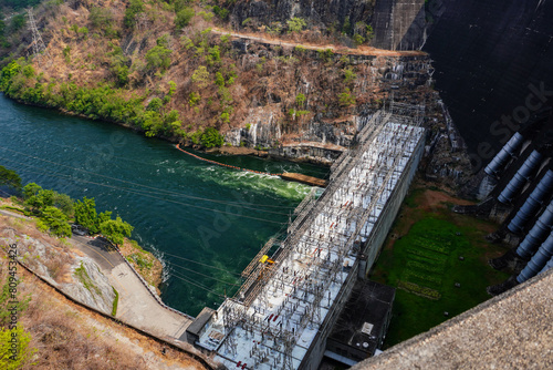 River dam amidst beautiful landscape with bridge, mountains and trees in summer, power plant at Bhumibol Dam in Thailand.