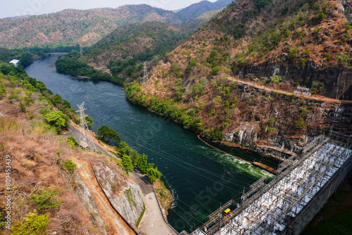 River dam amidst beautiful landscape with bridge, mountains and trees in summer, power plant at Bhumibol Dam in Thailand. photo