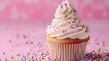   A pink background hosts a single cupcake, its white frosting crowned with colorful sprinkles