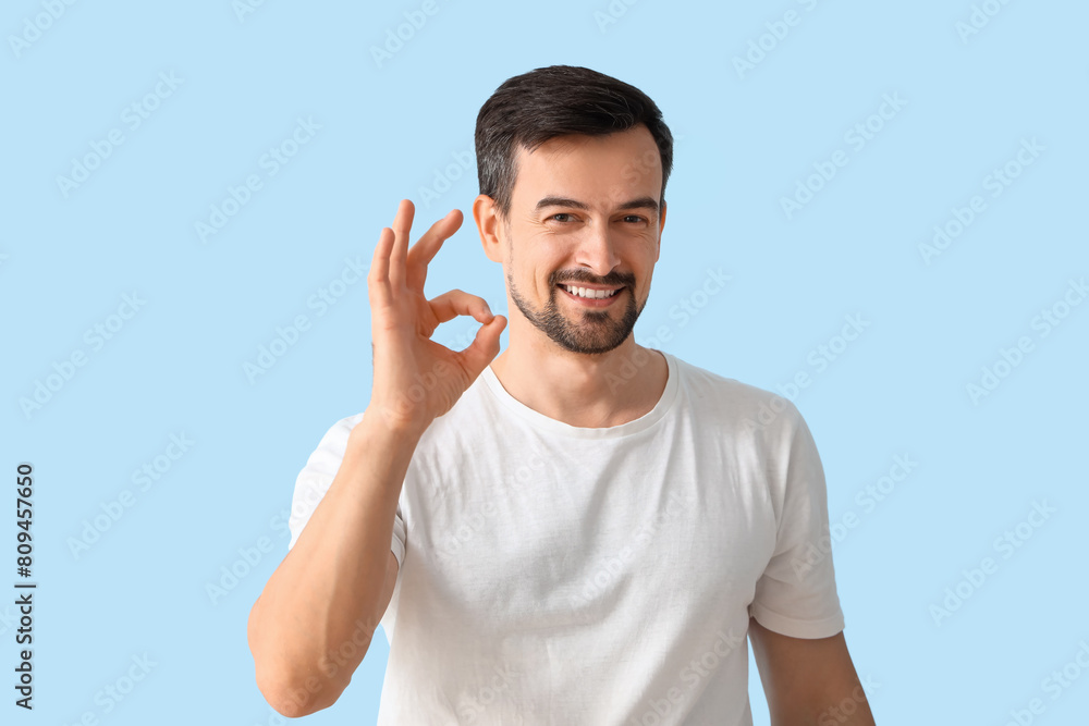 Handsome man showing OK on blue background Handsome man showing OK on blue background