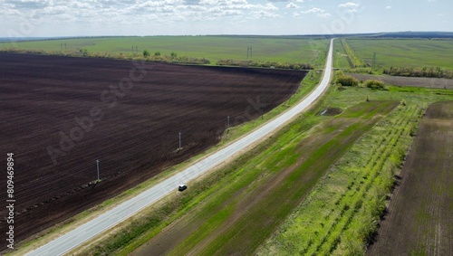 a road running along plowed empty fields ready for planting