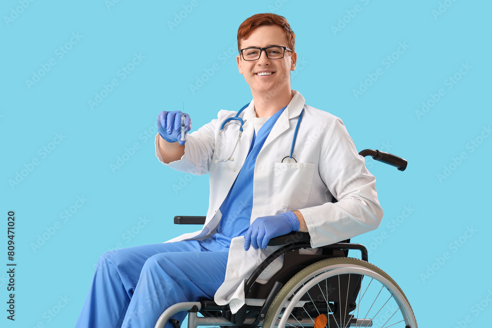 Male doctor in wheelchair with injection on blue background Male doctor in wheelchair with injection on blue background