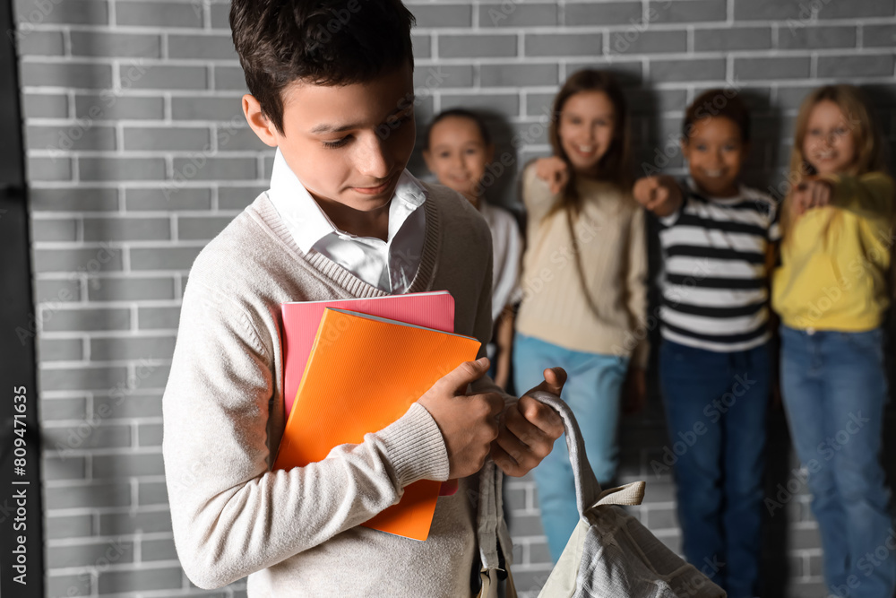 Bullied little boy with copybooks at school Bullied little boy with copybooks at school
