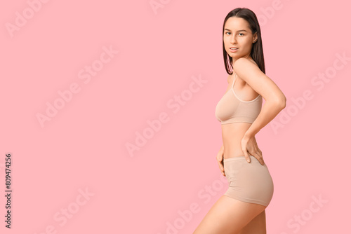 Beautiful young woman in beige underwear on pink background © Pixel-Shot