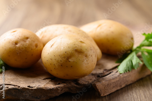 Raw potatoes on wooden background  Food ingredient