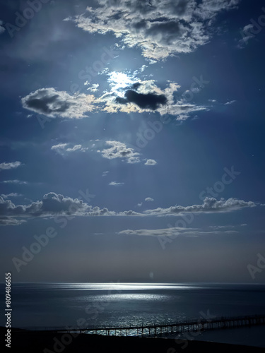 Moon over the lake. Full moon in the clouds. Kyrgyzstan, Lake Issyk-Kul