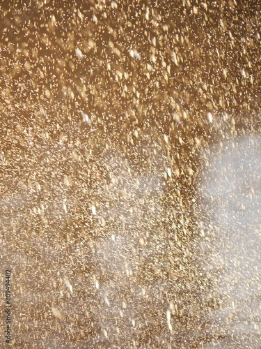 A blurry image of a snowstorm with a lot of gold dust in the air