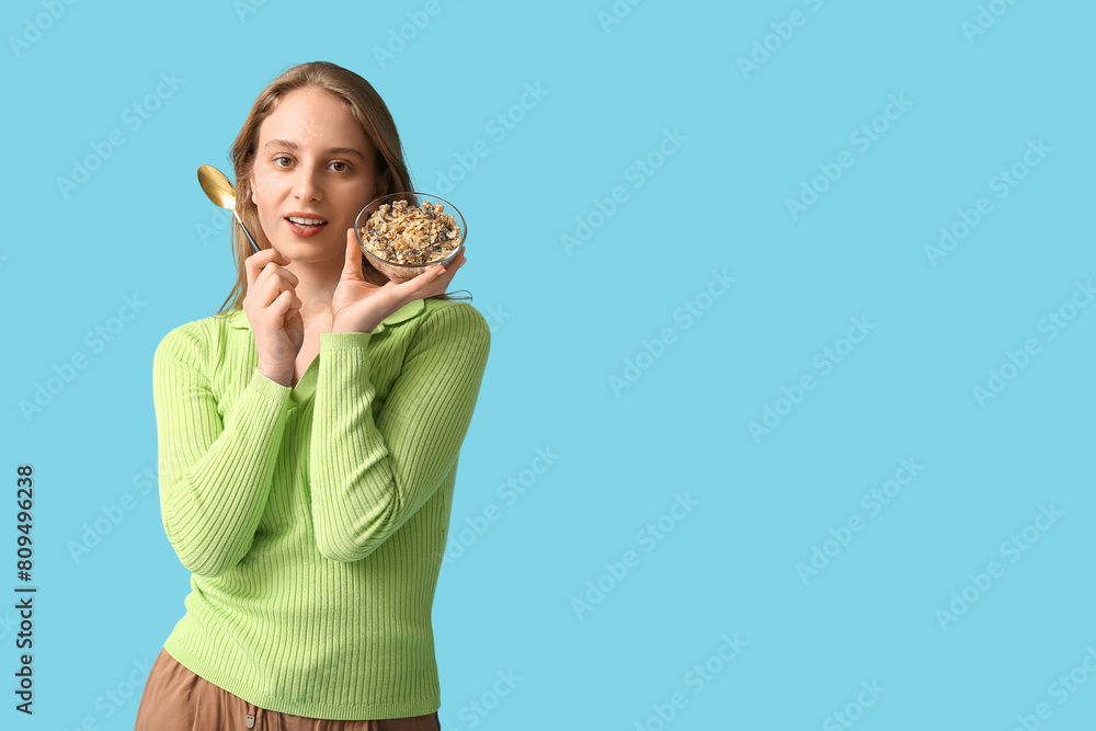 Young woman with bowl of healthy oatmeal on blue background Young woman with bowl of healthy oatmeal on blue background