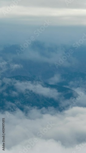 Vertical 4K Timelapse, Clouds and Dense Fog Inversions Above Valley and High Mountain Peaks photo