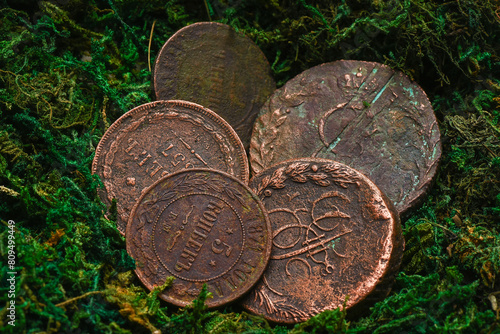 Old coins on the green moss background. Top view. photo