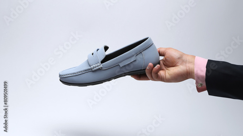 light blue leather loafers slip on shoes holding in hand