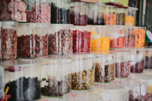TW-02.01.24:A close-up of preserved fruits in glass jars at a traditional Taiwanese snack shop, once common retail outlets in alleys and streets, offering a variety of snacks, beverages, and groceries
