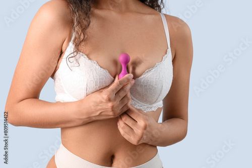 Young woman with butt plug on light background, closeup