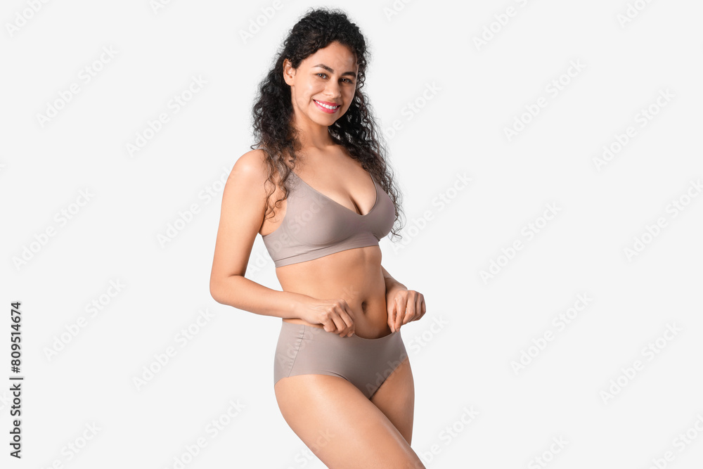 Fototapeta premium Young African-American woman in underwear on light background