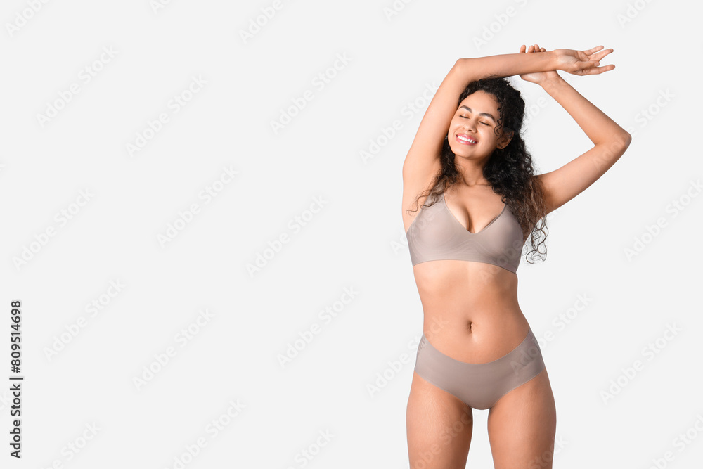 Young African-American woman in underwear on light background Young African-American woman in underwear on light background