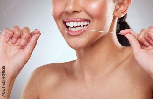 Dental floss, smile or teeth of person closeup in studio on gray background for cleaning and oral hygiene. Dentist, hands and mouth with product for tooth care to prevent cavity, decay or gum disease