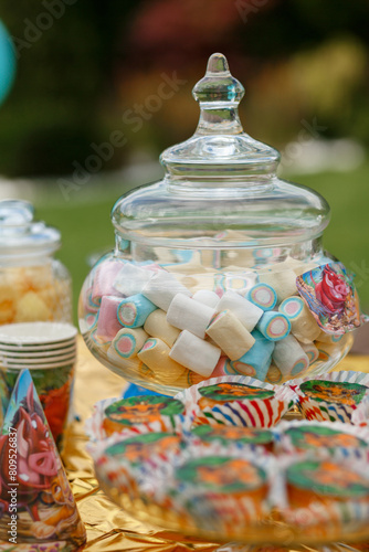 Multi-colored bright marshmallows in a glass jar with a lid