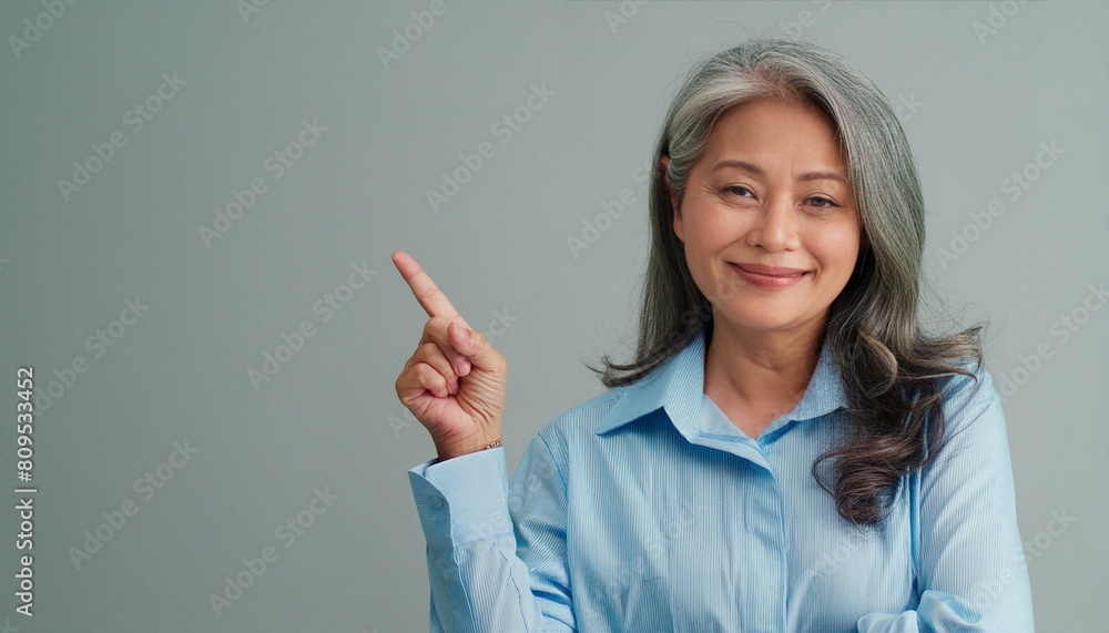 Businesswoman point with finger on gray background Businesswoman point with finger on gray background