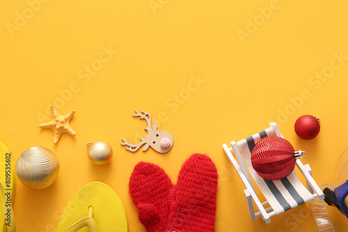 Composition with Christmas decorations, mittens and beach accessories on color background photo
