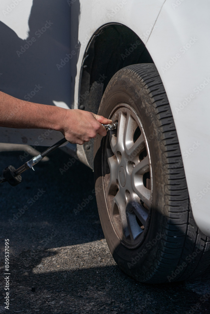 Man's hand inflating a car tire seen from close up. Car maintenance Man's hand inflating a car tire seen from close up. Car maintenance