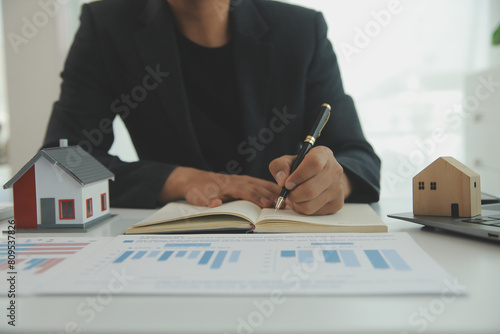 Tableau sur toile Businessmen holding pens, signing home titles with insurance, care about real estate services and the idea of real estate agents offering interest in installments to their customers