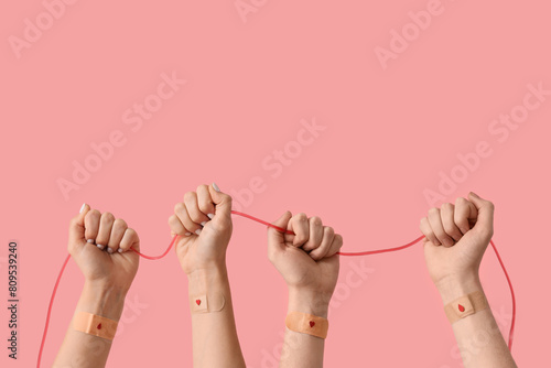 Quadro su tela Blood donors with applied patches and pack tube on pink background