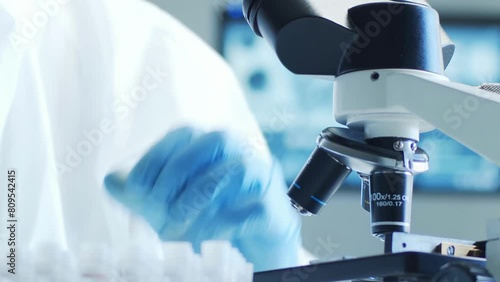 Scientist in protection suit and masks working in research lab using laboratory equipment: microscopes, test tubes. Medicine, healthcare and technology concept. photo