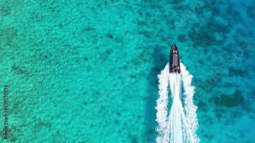 Drone top down tracking follows dive tour inflatable boat above Caribbean sandy reefs photo