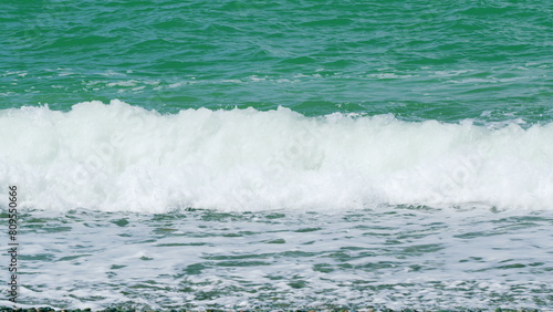 Sea Surface Near Shore. Waves Rolled On Sandy Shore. Turquoise Waves With Clear Water. Slow motion.