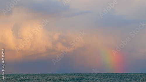 Arc Of Rainbow With Sunset Orange Clouds Tropical Sky. Rain And Thunderstorms. Static view.