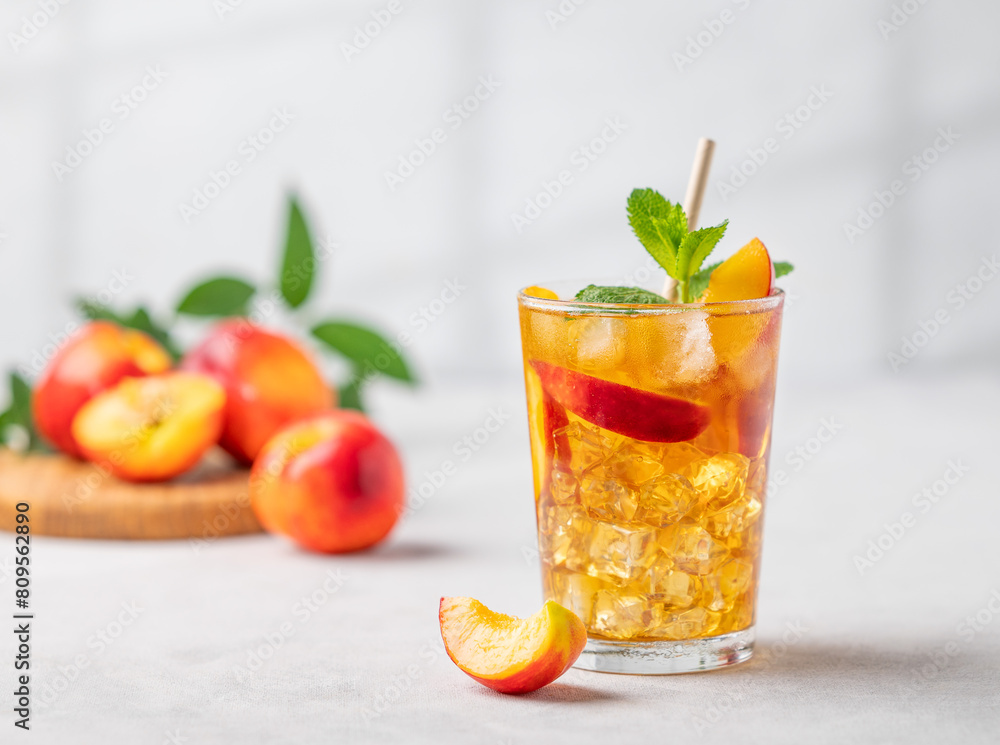 Refreshing peach iced mint tea. The concept of a healthy homemade cold summer drink in a tall glass Refreshing peach iced mint tea. The concept of a healthy homemade cold summer drink in a tall glass