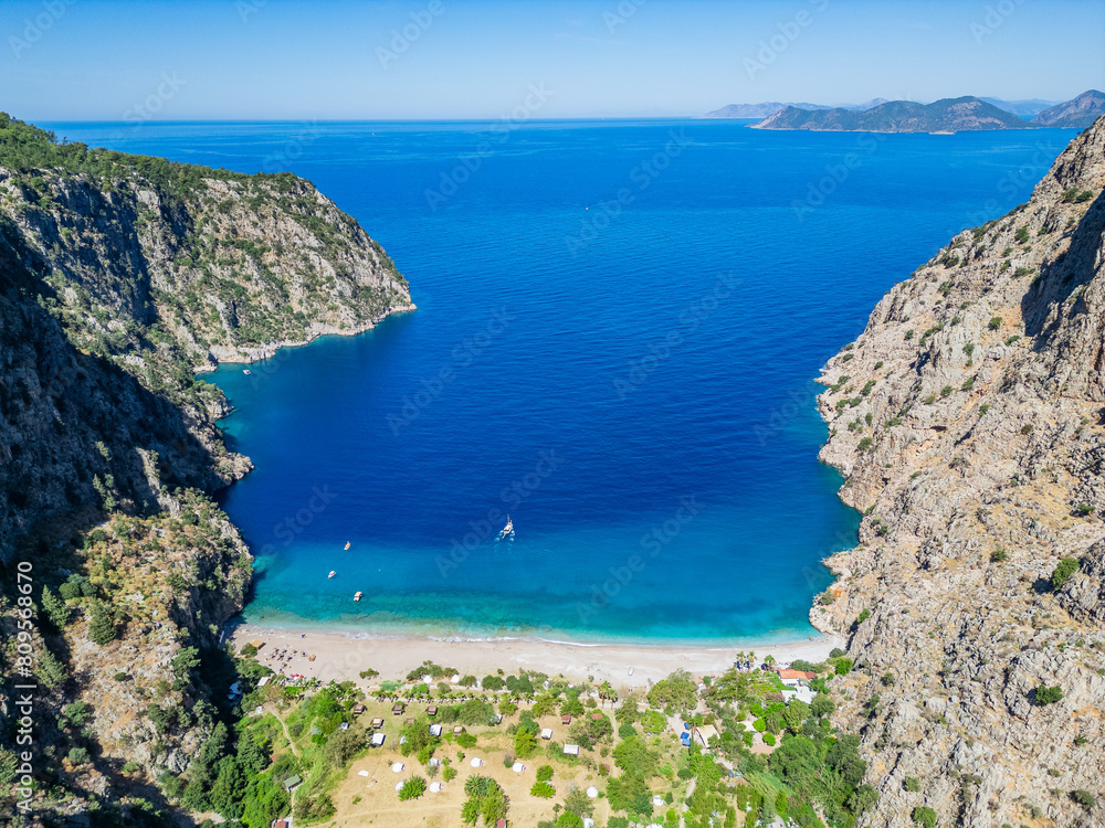 Fototapeta premium The most beautiful beach in the world and in Turkey is the Butterfly Valley on the Lycian Way in Fethiye. The sea is turquoise and the sand is unique. It can only be reached by boat. There are over 80