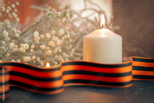 A burning candle and St. George's ribbon, a symbol of the victory of the Soviet people in Second World War photo