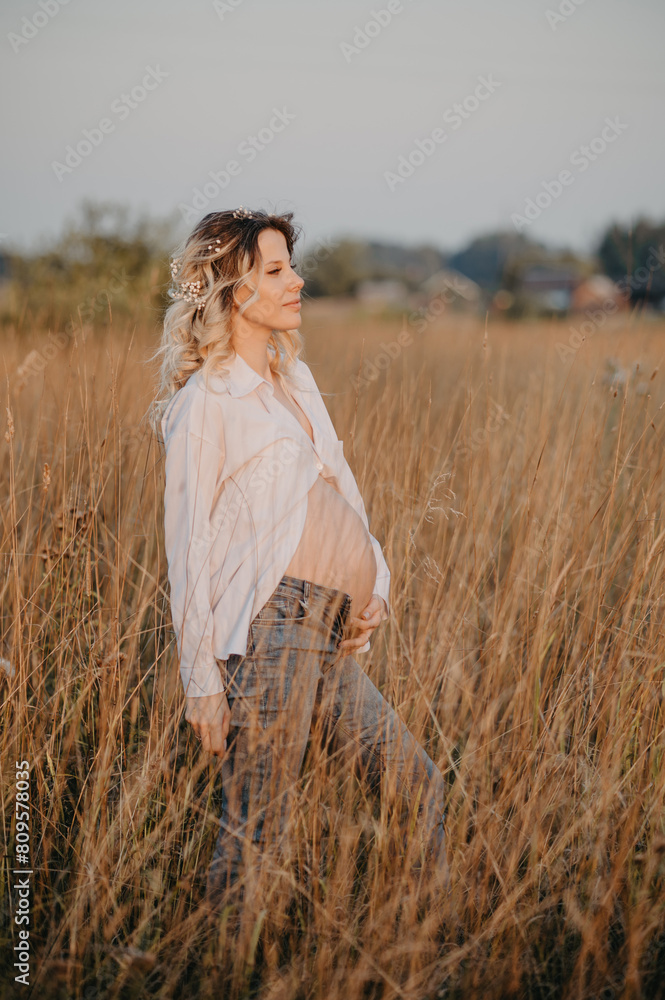 A happy future young mother is a woman in white clothes with a big pregnant belly. Natural landscape. The concept of pregnancy. A happy future young mother is a woman in white clothes with a big pregnant belly. Natural landscape. The concept of pregnancy.